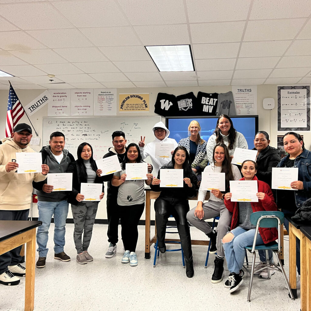 Adult students holding class certificates.