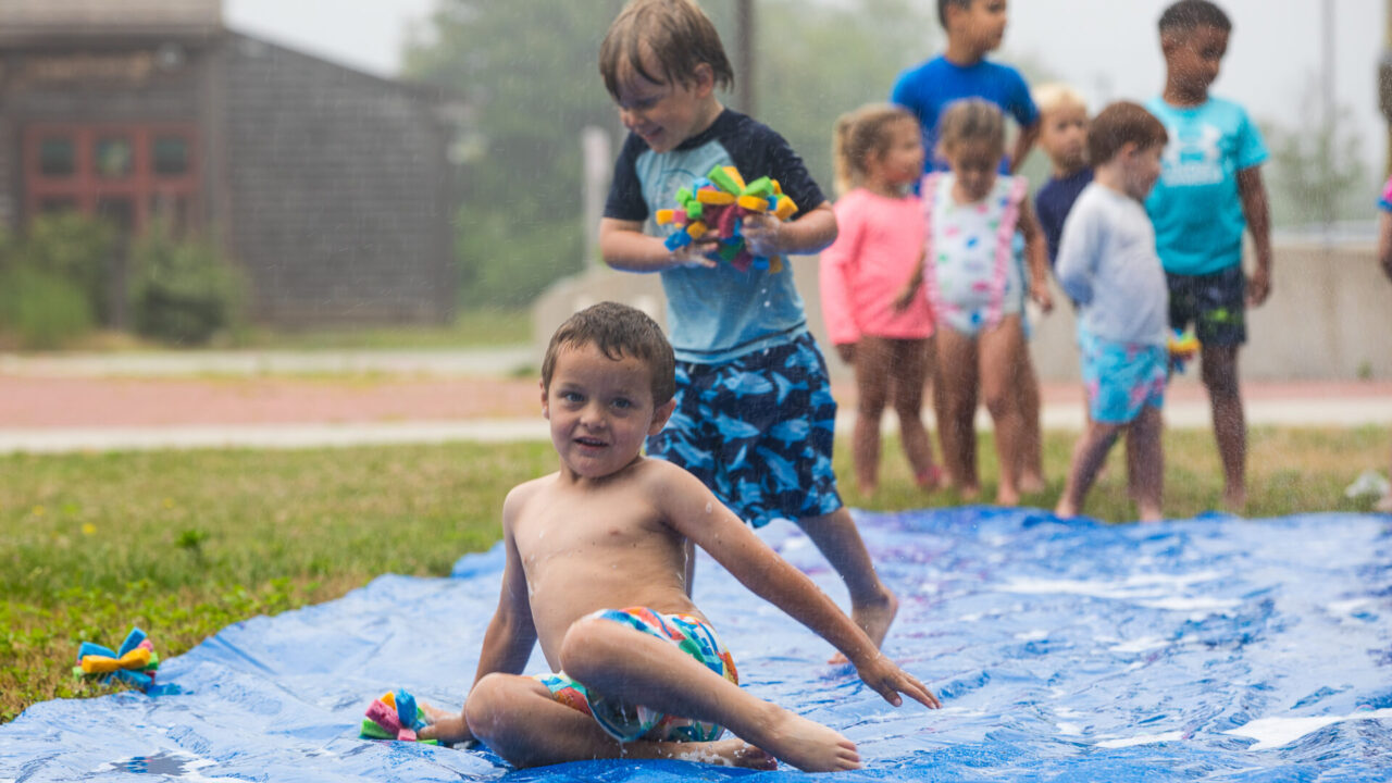 Young boy playing water games at summer camp.