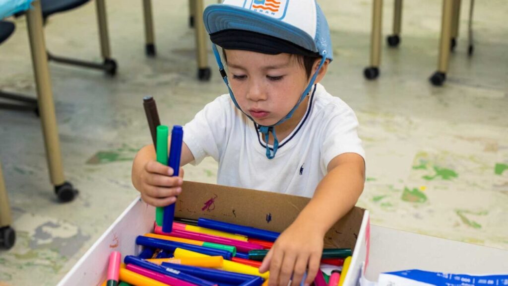 Young boy playing with markers.