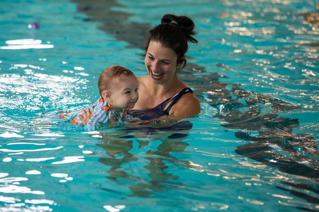 Woman and child enjoying a swim in a pool.